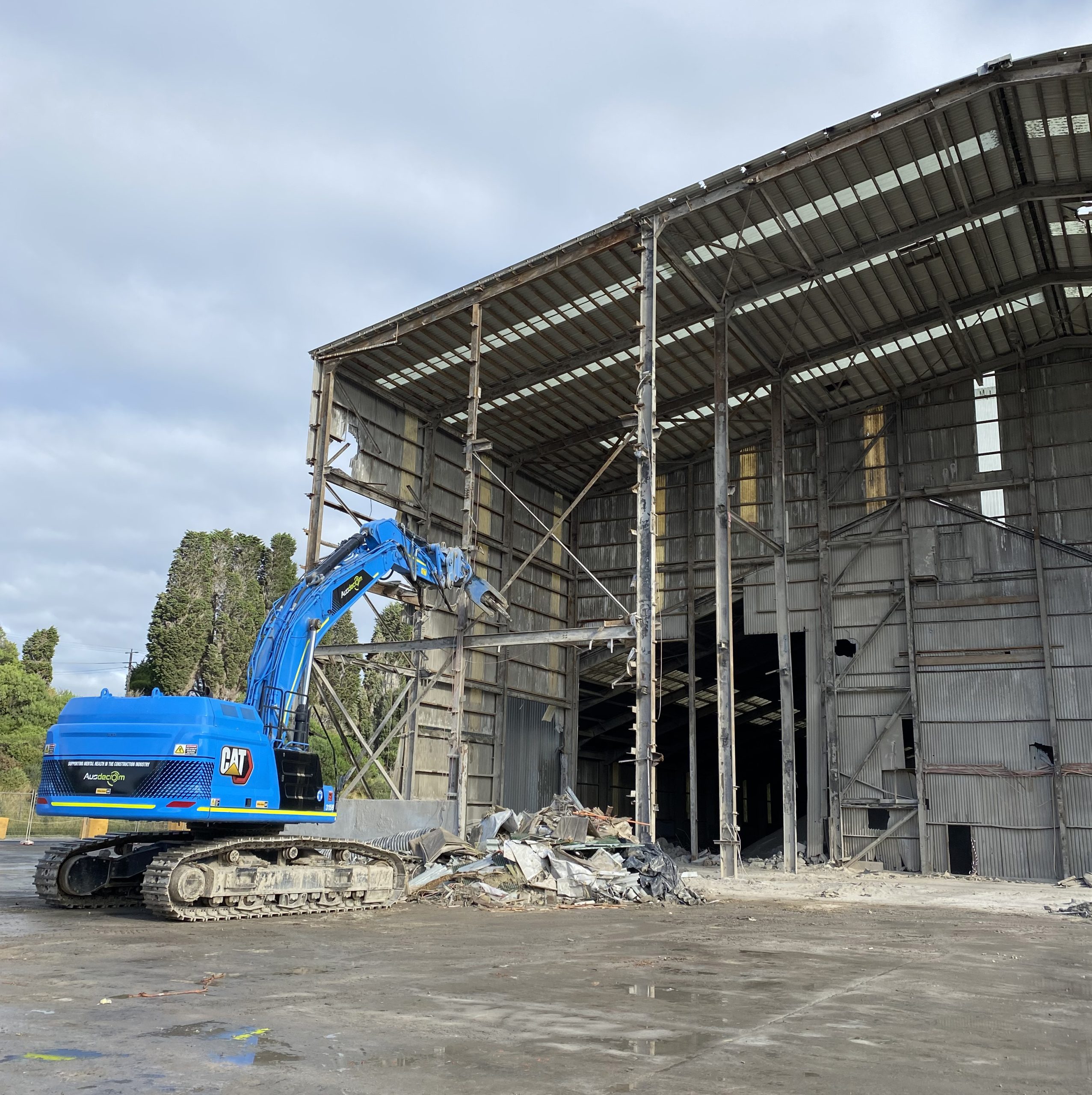 Ausdecom's Big Blue Excavator Demolishing Shed